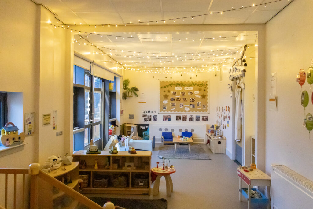The two to three years section of the nursery. There are age-appropriate toys and activities, and fairy lights across the ceiling.