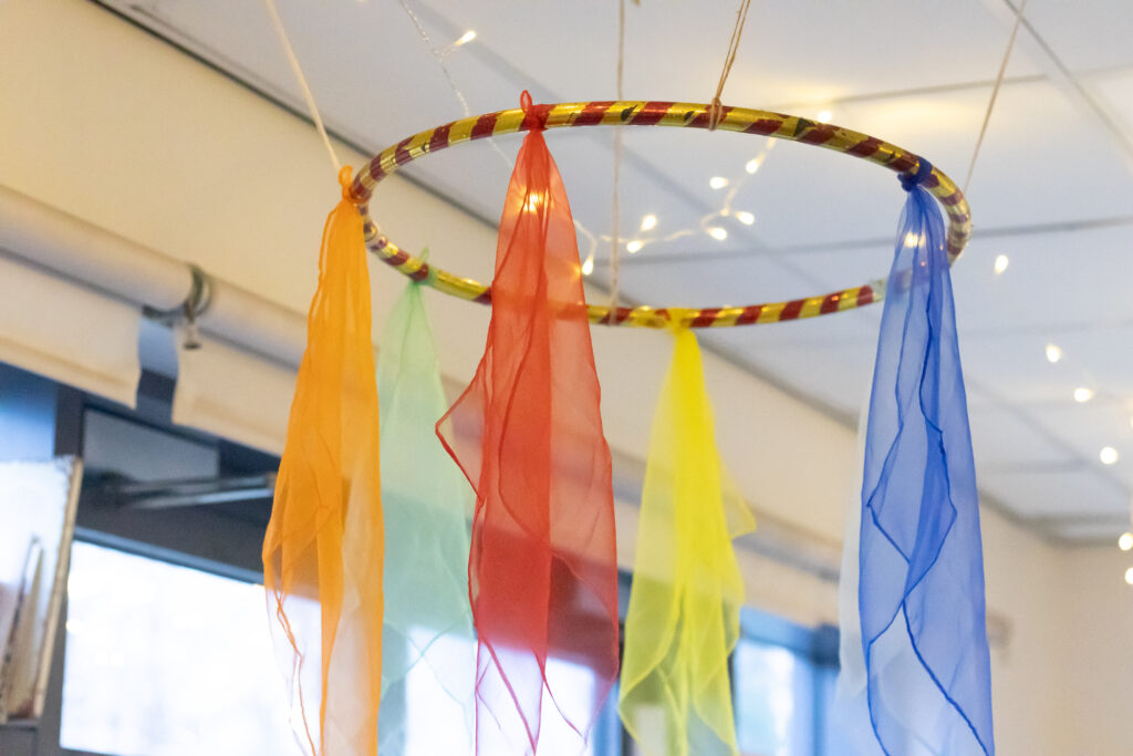 Close-up of multi-coloured silk cloth  decoration hanging from the ceiling of a nursery room.