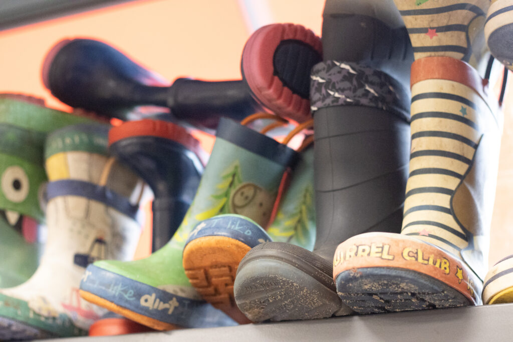 Close up of childrens' wellies on a shelf.